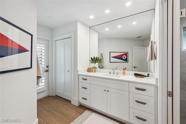 bathroom featuring wood finished floors, vanity, and recessed lighting