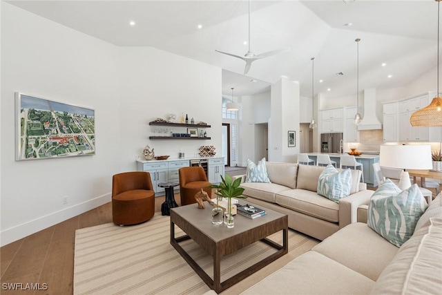 living room featuring beverage cooler, high vaulted ceiling, and light hardwood / wood-style floors