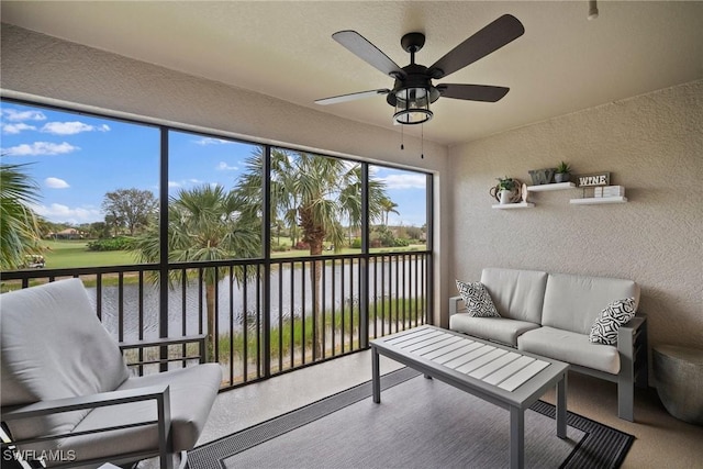 sunroom featuring a water view and ceiling fan