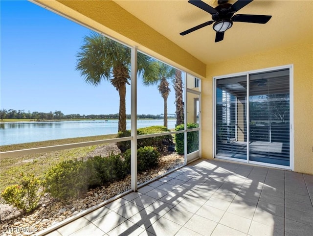 unfurnished sunroom featuring a water view and ceiling fan