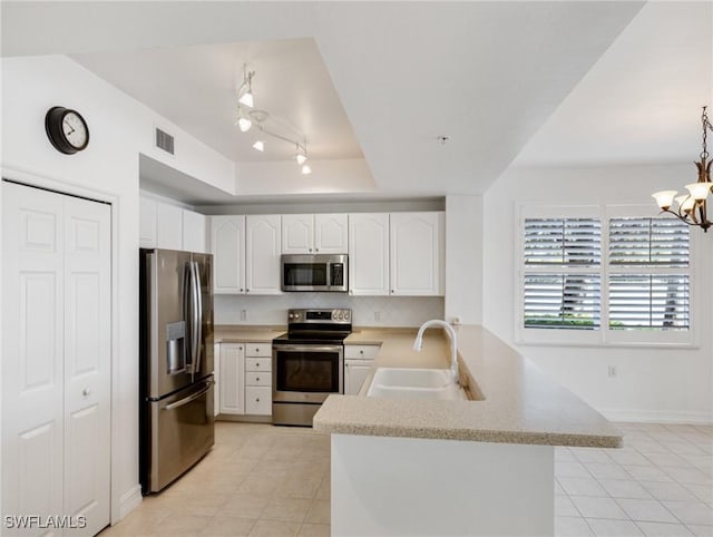 kitchen with appliances with stainless steel finishes, white cabinetry, and kitchen peninsula