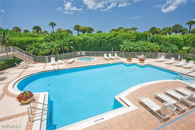 view of swimming pool featuring a hot tub and a patio