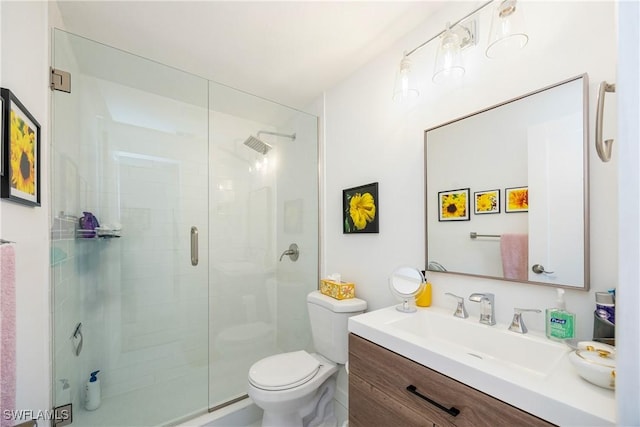 bathroom featuring vanity, a shower with door, and toilet