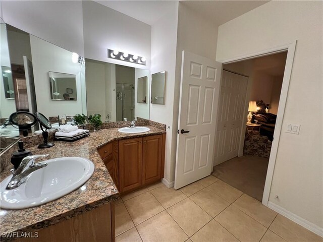 bathroom with a sink, tile patterned floors, a stall shower, and baseboards