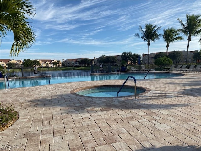 community pool with a patio, a residential view, and a hot tub