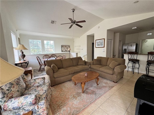 living area with light tile patterned floors, visible vents, vaulted ceiling, and ceiling fan