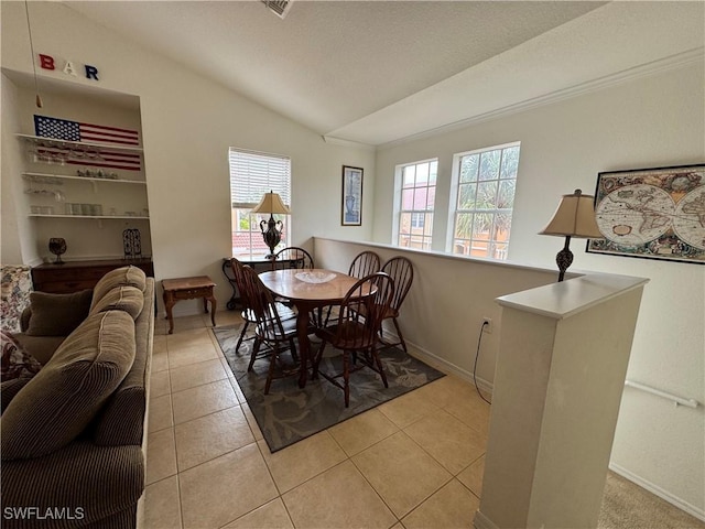 dining room featuring light tile patterned floors, baseboards, and lofted ceiling