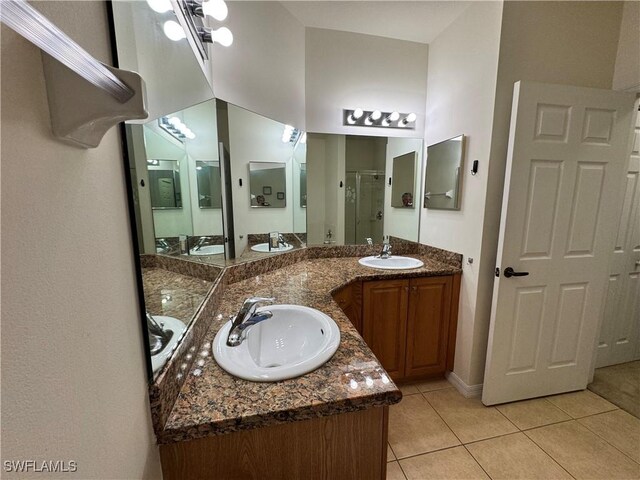 bathroom with tile patterned floors, vanity, and a stall shower