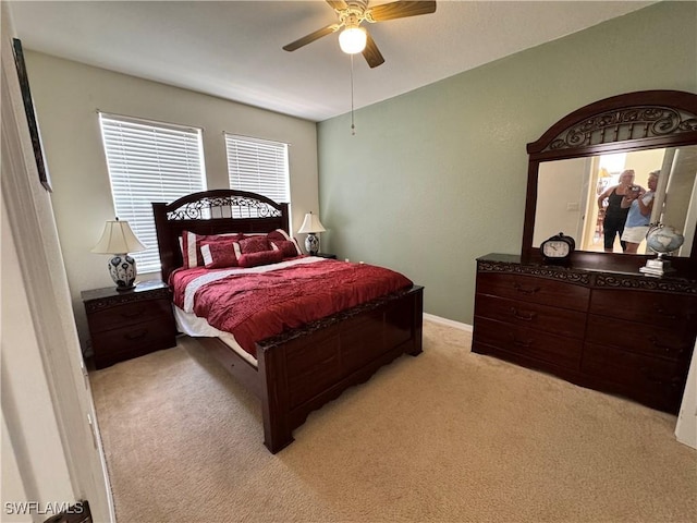 bedroom with baseboards, a ceiling fan, and light carpet