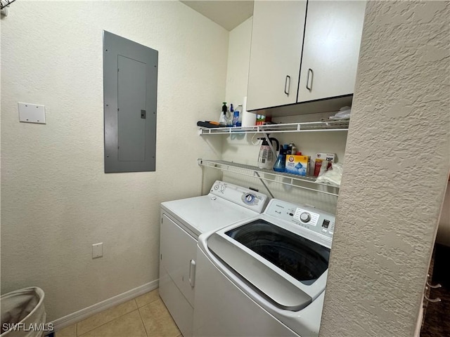 clothes washing area with baseboards, separate washer and dryer, electric panel, cabinet space, and light tile patterned flooring