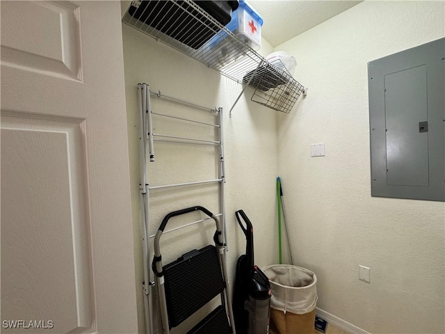 clothes washing area featuring baseboards and electric panel