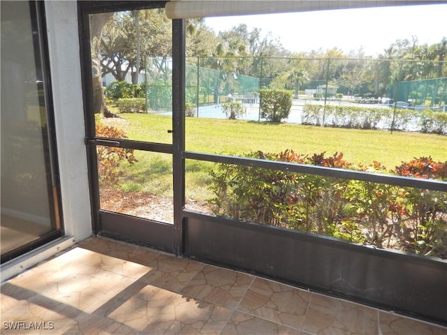 unfurnished sunroom featuring a water view