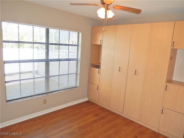 unfurnished bedroom featuring ceiling fan, light hardwood / wood-style floors, and a closet