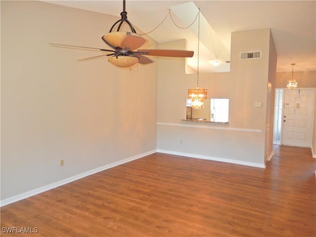 unfurnished living room with ceiling fan with notable chandelier, wood-type flooring, and high vaulted ceiling