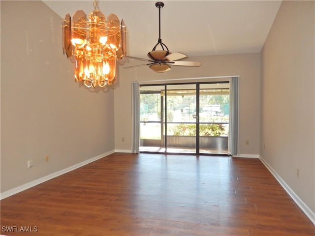 empty room with ceiling fan with notable chandelier, baseboards, and wood finished floors