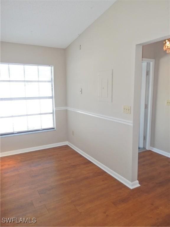 unfurnished room featuring dark wood-type flooring and vaulted ceiling