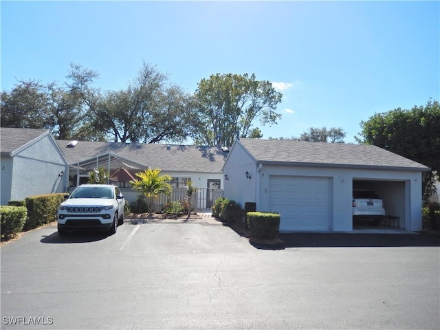 single story home featuring a garage, fence, and stucco siding