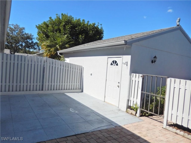 view of outbuilding featuring fence and a gate