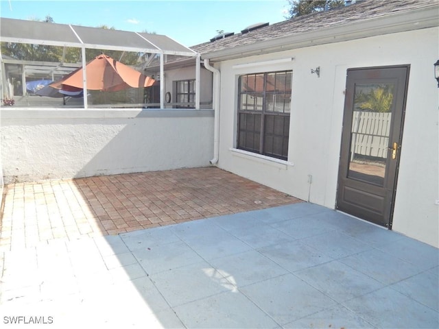 view of patio featuring glass enclosure