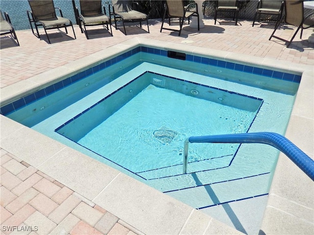 view of swimming pool featuring an in ground hot tub and a patio