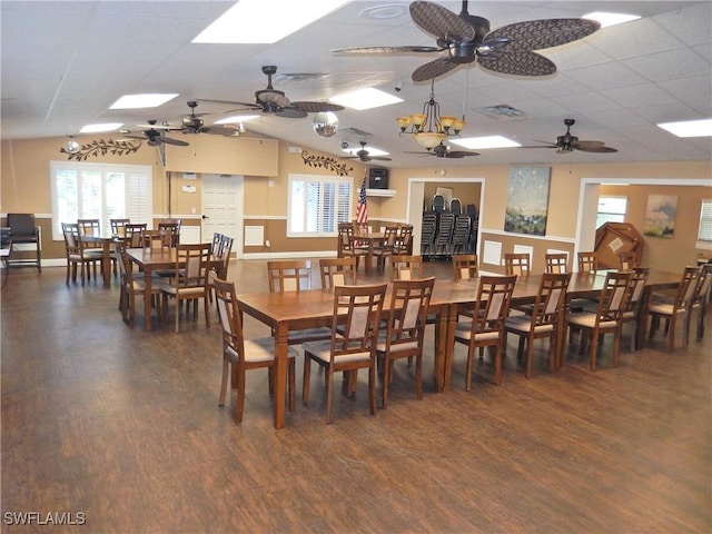 dining space with dark wood-type flooring and a drop ceiling