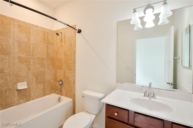 full bathroom featuring tiled shower / bath combo, vanity, and toilet