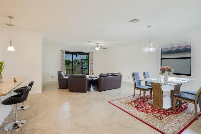 dining space with ornamental molding and ceiling fan with notable chandelier