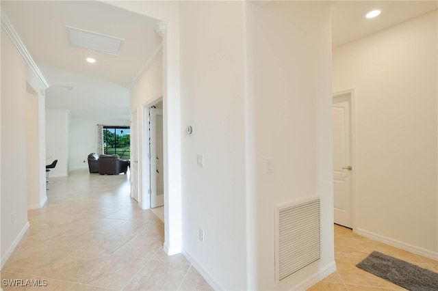 hall with crown molding and light tile patterned floors