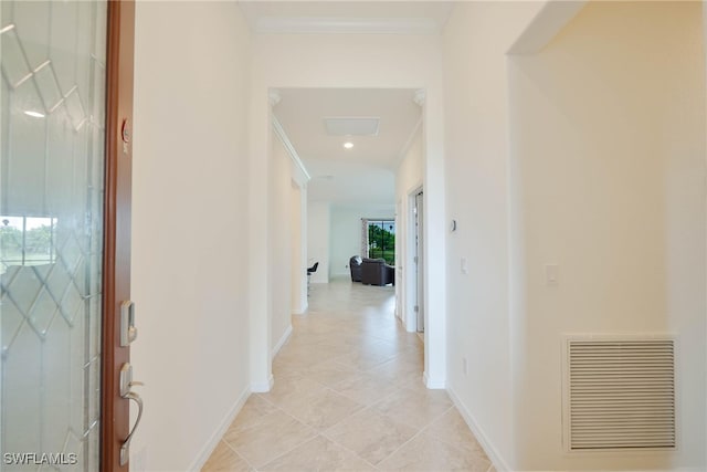 corridor with crown molding and light tile patterned floors