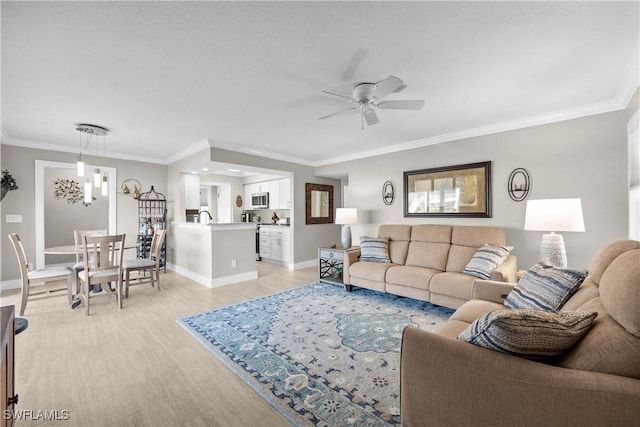 living room with crown molding, light hardwood / wood-style flooring, and ceiling fan