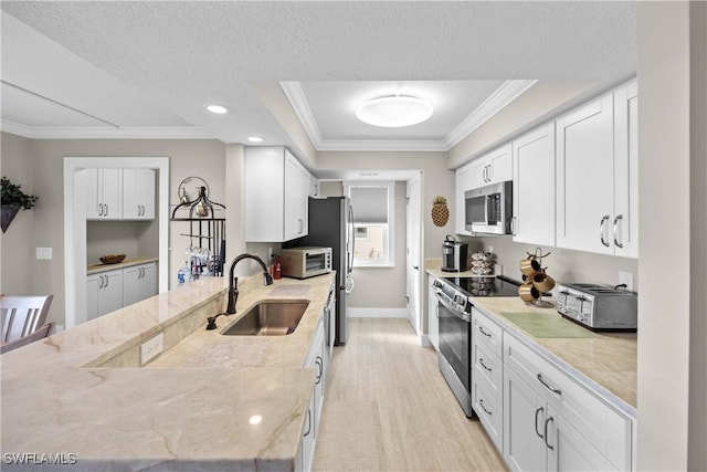 kitchen featuring sink, white cabinets, light stone counters, stainless steel appliances, and a textured ceiling