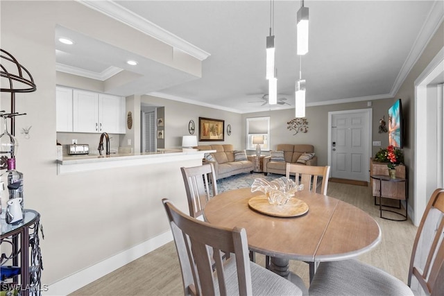 dining space featuring ornamental molding, light hardwood / wood-style floors, and ceiling fan