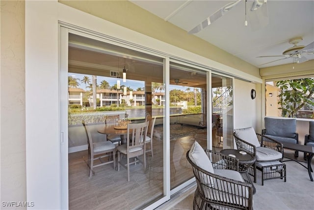 sunroom / solarium featuring ceiling fan