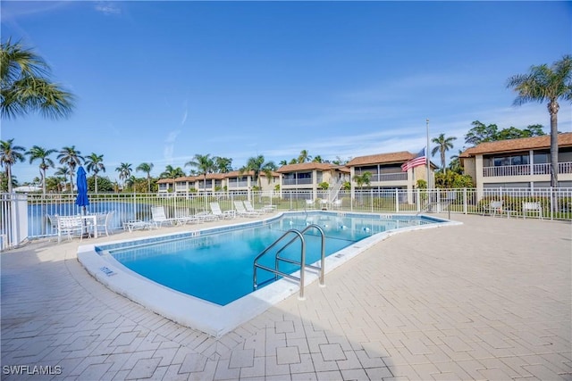 view of swimming pool with a patio and a water view