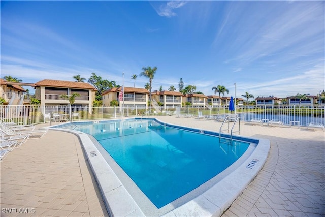 view of swimming pool featuring a patio and a water view