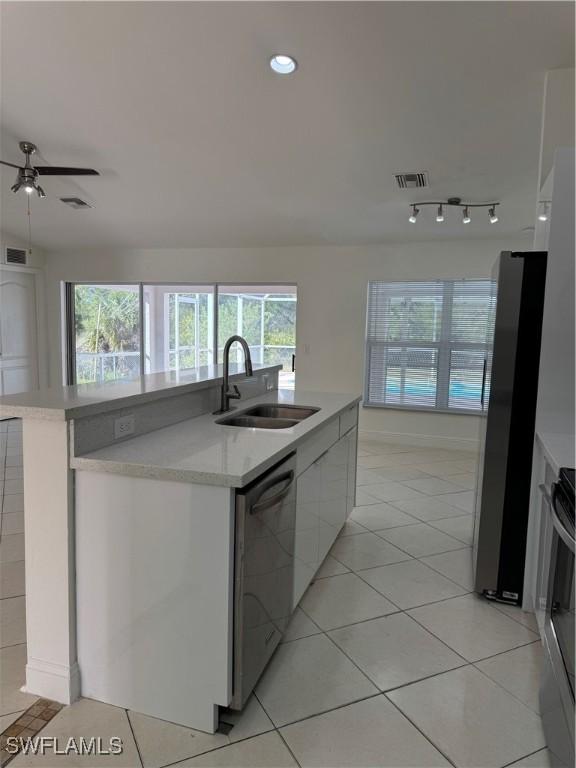 kitchen with a sink, visible vents, light countertops, appliances with stainless steel finishes, and modern cabinets