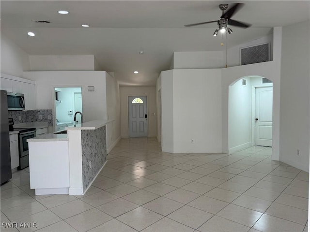 kitchen featuring arched walkways, a sink, visible vents, light countertops, and appliances with stainless steel finishes