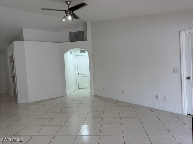 unfurnished room featuring arched walkways, light tile patterned floors, visible vents, a ceiling fan, and vaulted ceiling