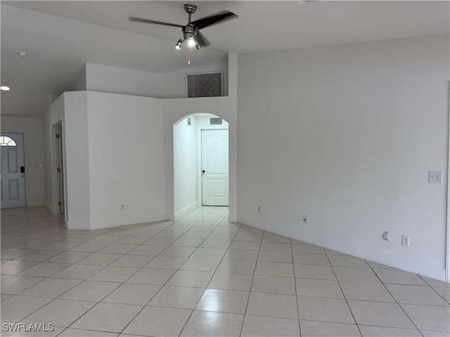 unfurnished room with light tile patterned floors, visible vents, arched walkways, baseboards, and a ceiling fan