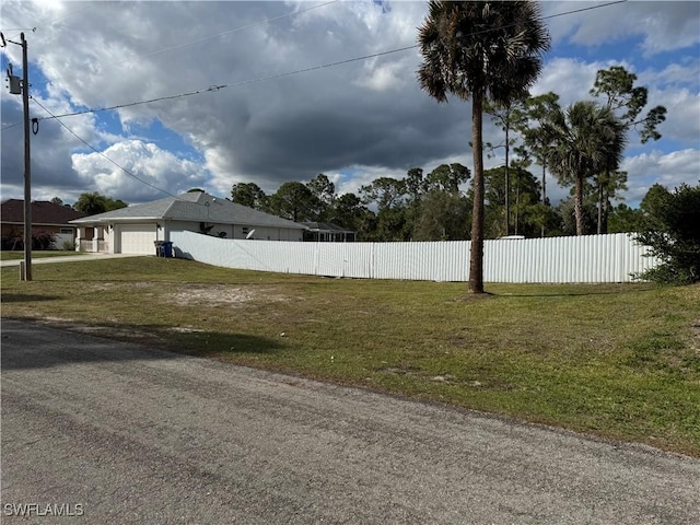 view of yard featuring a garage and fence