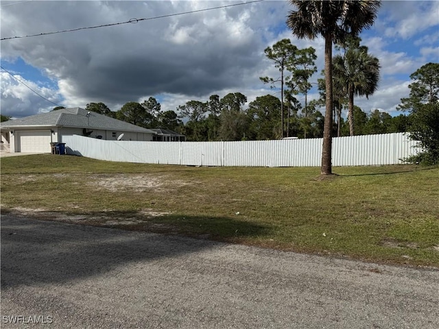 view of yard with fence and an attached garage