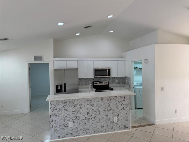 kitchen with washer / dryer, visible vents, appliances with stainless steel finishes, and white cabinets