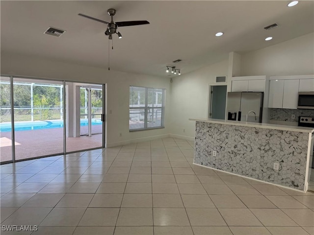 kitchen featuring light tile patterned floors, visible vents, appliances with stainless steel finishes, and vaulted ceiling