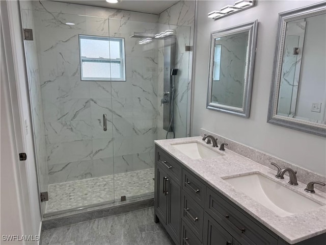 bathroom with double vanity, a sink, and a marble finish shower