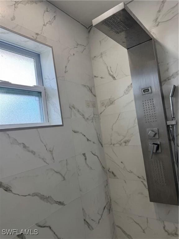 bathroom featuring a marble finish shower