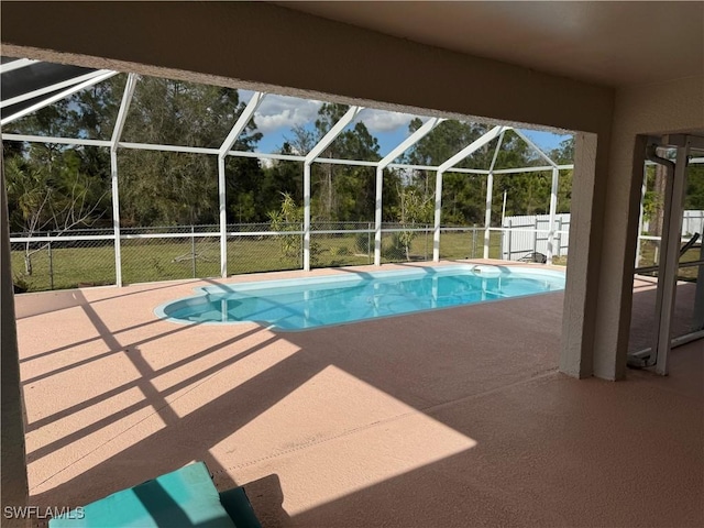 outdoor pool with a lanai, a patio area, and fence