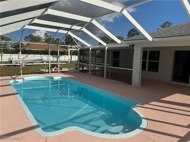 view of swimming pool featuring glass enclosure, a patio area, fence, and a fenced in pool