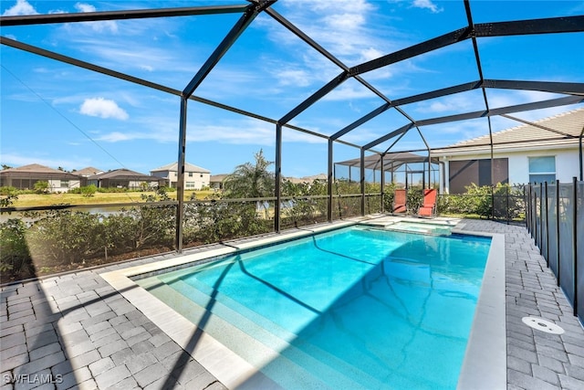 view of pool with a patio area and glass enclosure