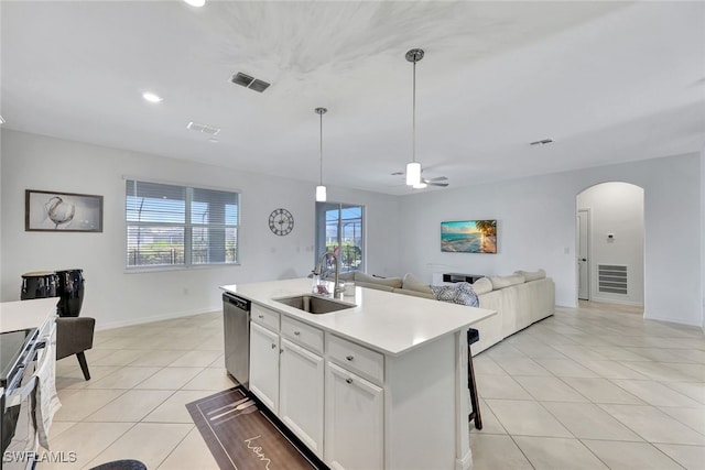 kitchen with light tile patterned flooring, sink, a center island with sink, stainless steel appliances, and white cabinets