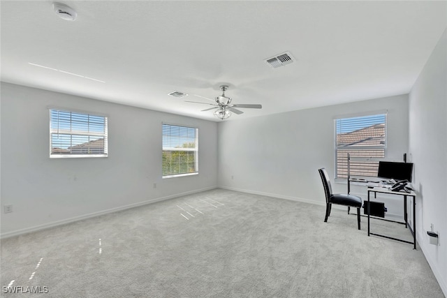 carpeted office space with ceiling fan